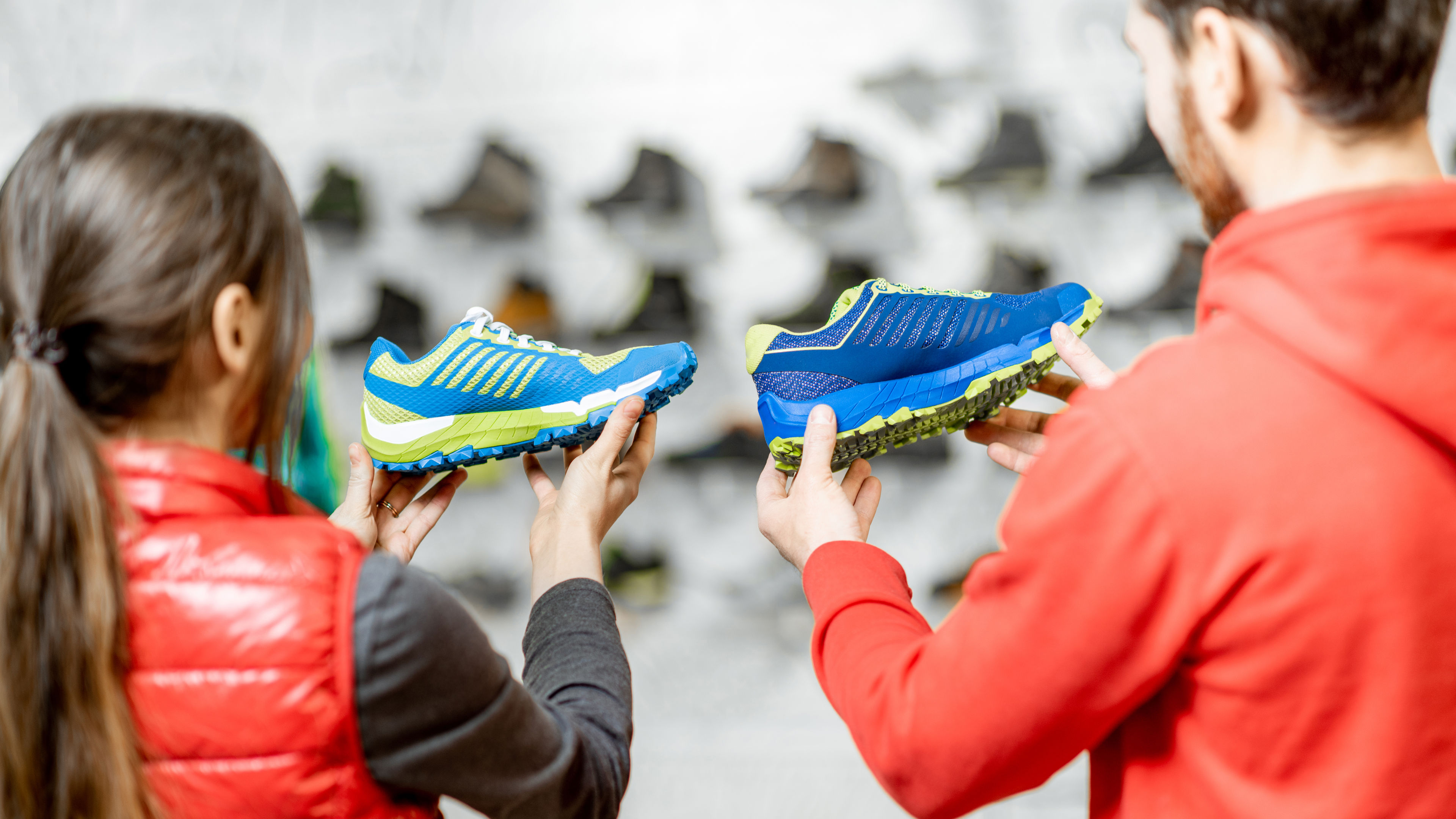 Couple holding shoes on hand.